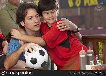 Close-up of a boy hugging his father