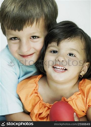 Close-up of a boy hugging his sister from behind