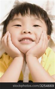Close-up of a boy leaning on his elbows and smiling