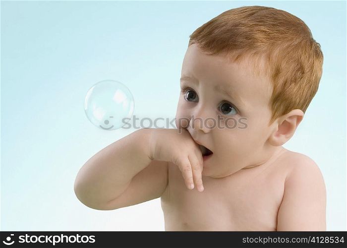 Close-up of a boy looking at a bubble