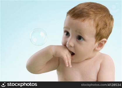 Close-up of a boy looking at a bubble