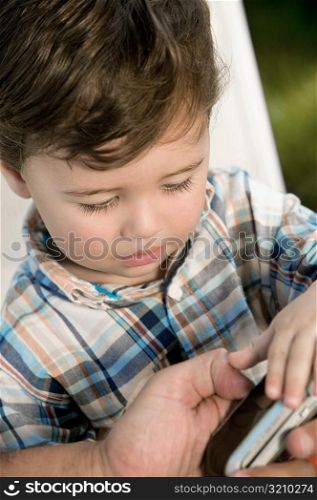 Close-up of a boy looking at a mobile phone