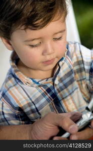 Close-up of a boy looking at a mobile phone