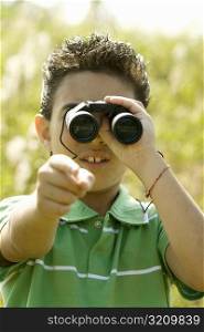 Close-up of a boy looking through a pair of binoculars