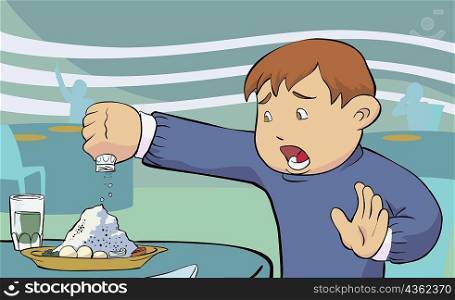Close-up of a boy pouring salt on food