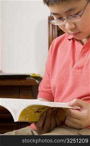 Close-up of a boy reading a book