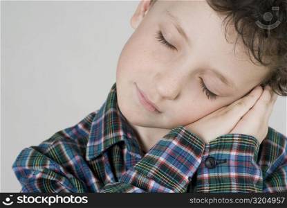 Close-up of a boy resting his face on his hands