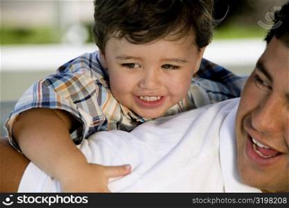 Close-up of a boy riding piggyback on his father