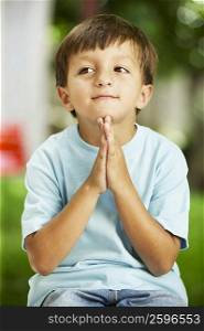Close-up of a boy sitting in a prayer position