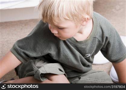 Close-up of a boy sitting on the floor