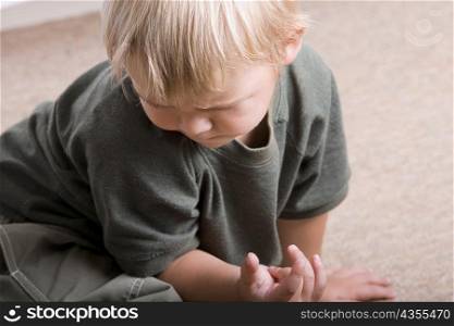 Close-up of a boy sitting on the floor