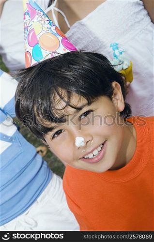 Close-up of a boy smiling with cake on his nose