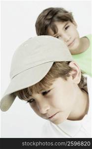 Close-up of a boy thinking with his friend in the background