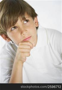 Close-up of a boy thinking with his hand on his chin