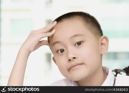 Close-up of a boy thinking with his head in his hands