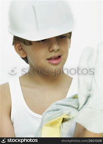 Close-up of a boy wearing a hardhat and gloves