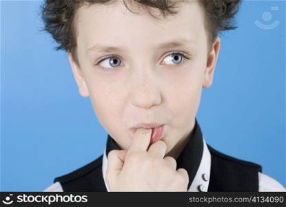 Close-up of a boy with his finger in his mouth