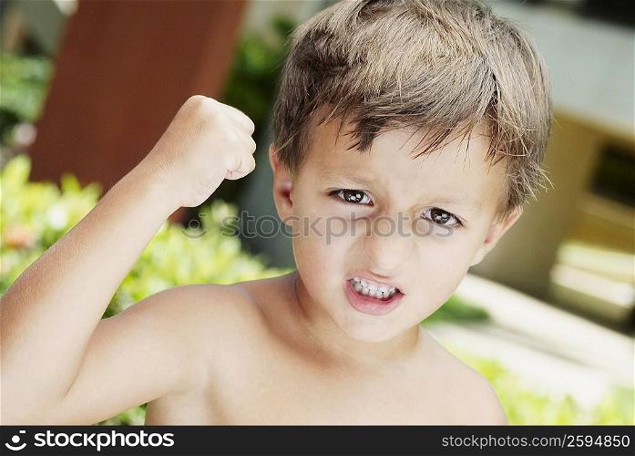 Close-up of a boy with his fist raised in anger