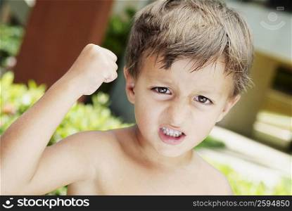 Close-up of a boy with his fist raised in anger