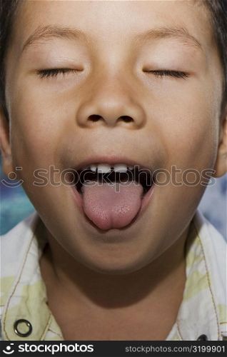 Close-up of a boy with sticking his tongue out