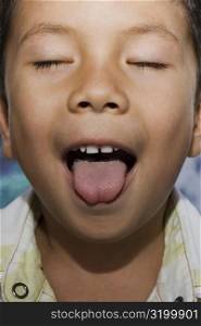 Close-up of a boy with sticking his tongue out