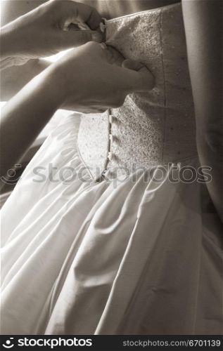 Close-up of a bridal dress being buttoned ( black and white )