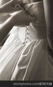 Close-up of a bridal dress being buttoned ( black and white )