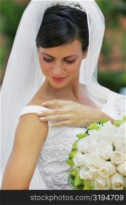 Close-up of a bride holding a bouquet of flowers and smiling