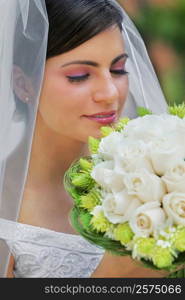 Close-up of a bride smelling a bouquet of flowers