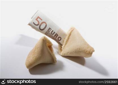 Close-up of a broken fortune cookie with fifty Euro dollars