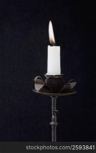 Close-up of a burning candle on a candlestick holder