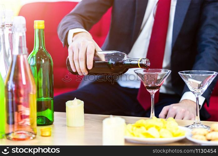 Close up of a business suit of man Pouring champagne into glass on xmas and the new years eve party,Party after work concept
