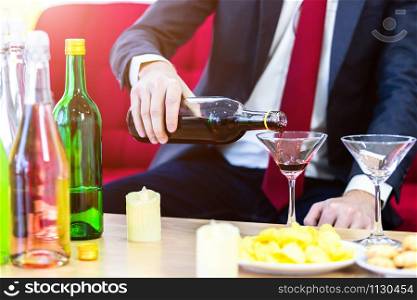 Close up of a business suit of man Pouring champagne into glass on xmas and the new years eve party,Party after work concept