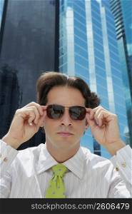 Close-up of a businessman adjusting his sunglasses