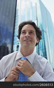 Close-up of a businessman adjusting his tie