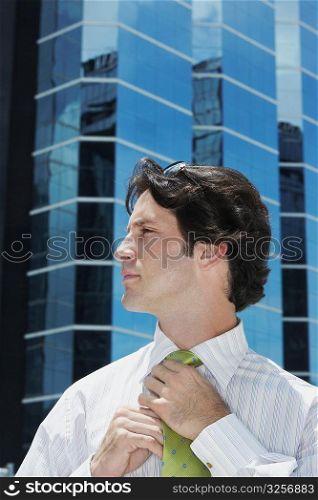 Close-up of a businessman adjusting his tie