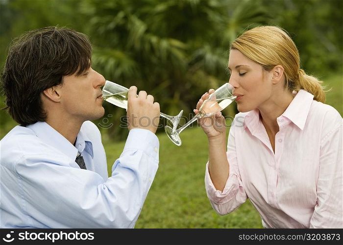 Close-up of a businessman and a businesswoman drinking champagne