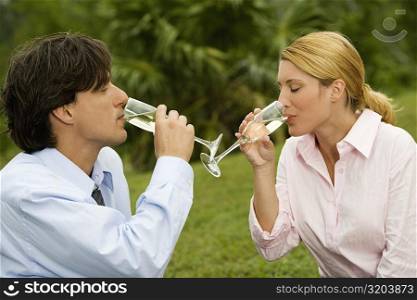 Close-up of a businessman and a businesswoman drinking champagne