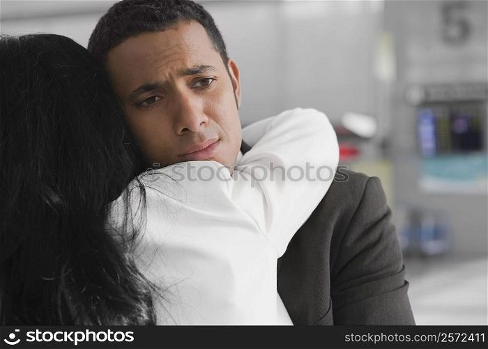Close-up of a businessman and a businesswoman embracing each other at an airport