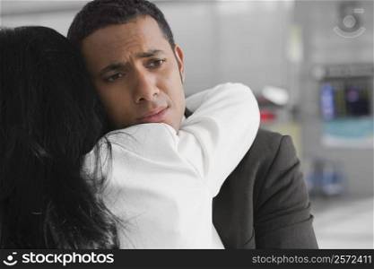 Close-up of a businessman and a businesswoman embracing each other at an airport