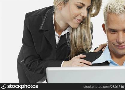 Close-up of a businessman and a businesswoman in front of a laptop