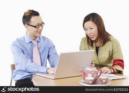 Close-up of a businessman and a businesswoman in front of a laptop