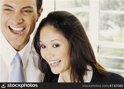 Close-up of a businessman and a businesswoman laughing