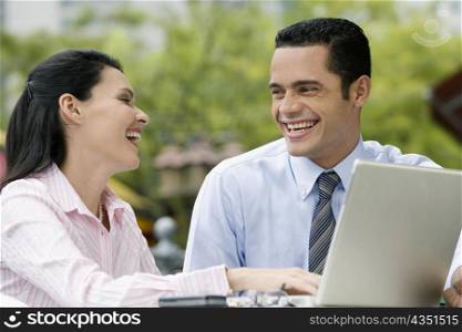 Close-up of a businessman and a businesswoman looking at each other and smiling