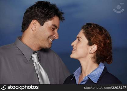 Close-up of a businessman and a businesswoman looking at each other smiling