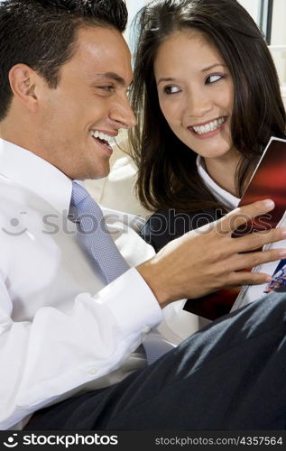 Close-up of a businessman and a businesswoman reading a book