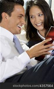 Close-up of a businessman and a businesswoman reading a book