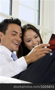 Close-up of a businessman and a businesswoman reading a magazine