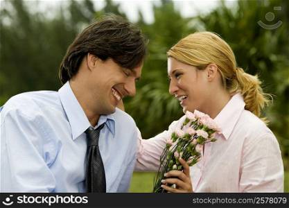 Close-up of a businessman and a businesswoman smiling in the park
