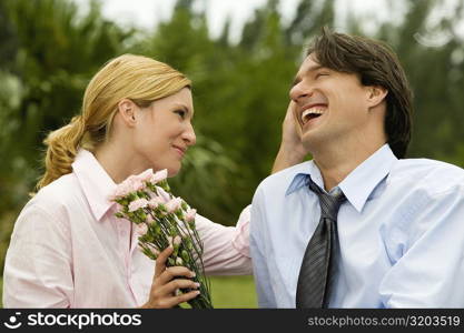 Close-up of a businessman and a businesswoman smiling in the park